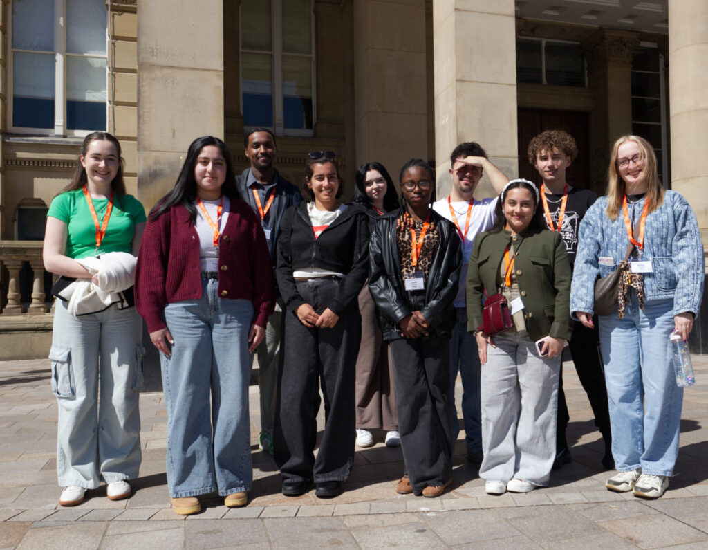 Young people standing in a group outside, smiling
